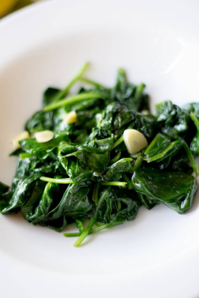 Close-up photo of Spinach sautéed with lemon and garlic. 