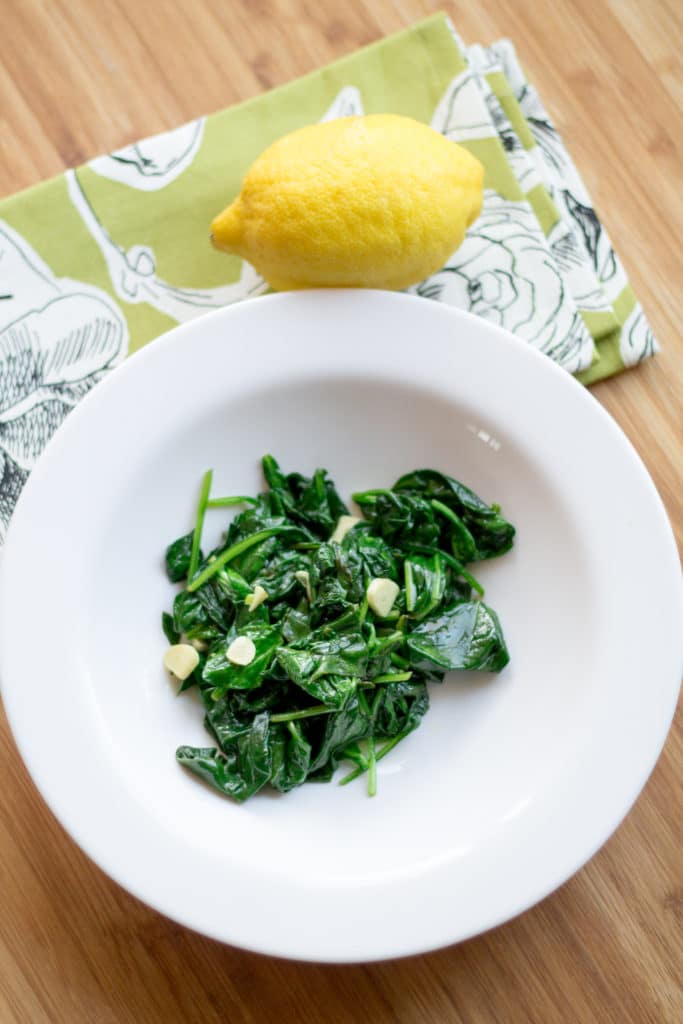 Spinach sautéed with lemon and garlic in a bowl on a table