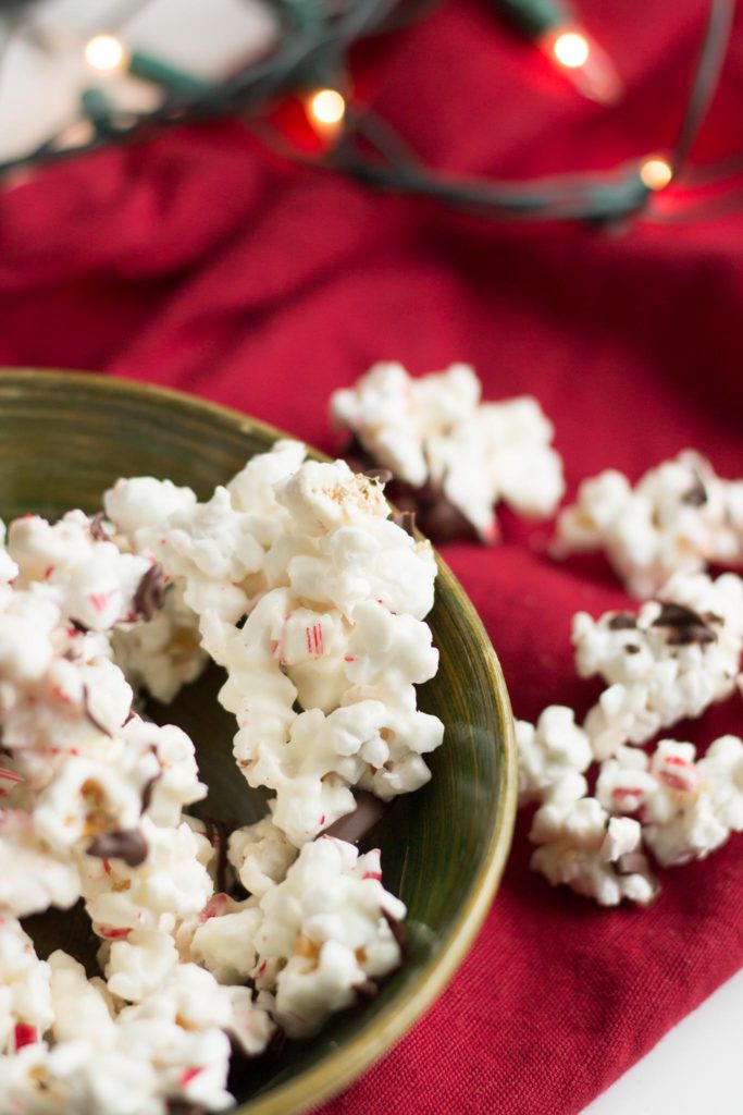 Holly Jolly Peppermint Popcorn | Popcorn covered in vanilla almond bark, crushed candy cane and chocolate.