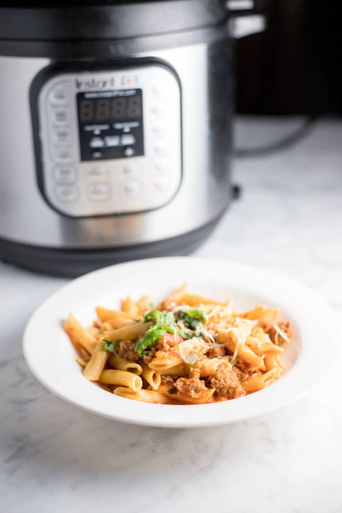 penne in a bowl next to an instant pot