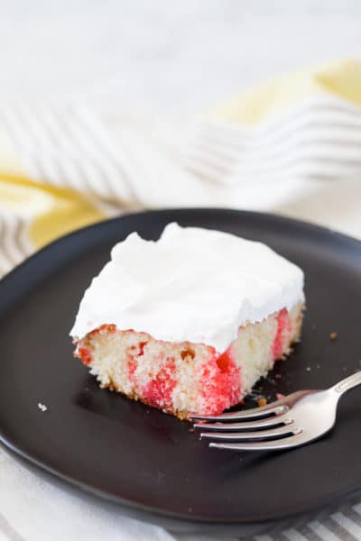 a slice of jello poke cake on a plate with a fork