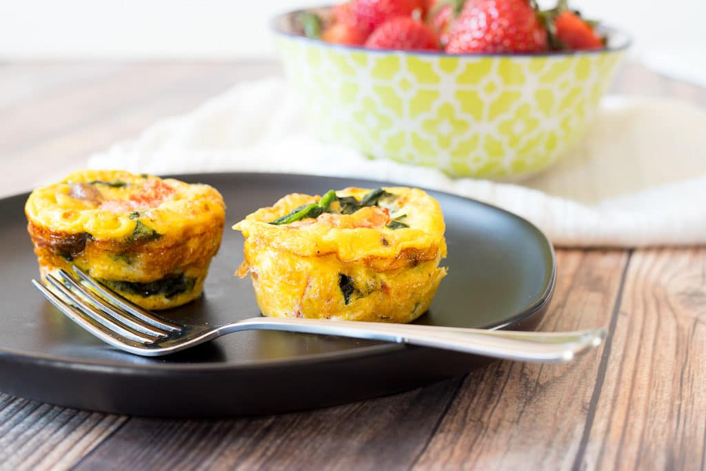 two egg bake muffins on a plate with a fork 